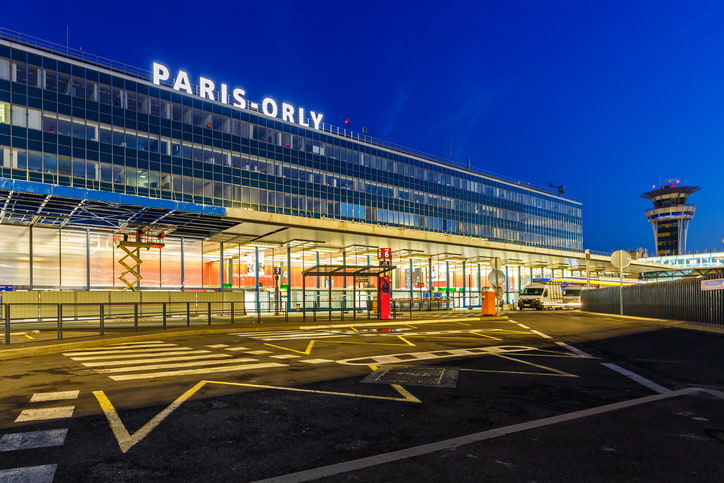Front of Orly Airport in Paris at night with airport name lit up
