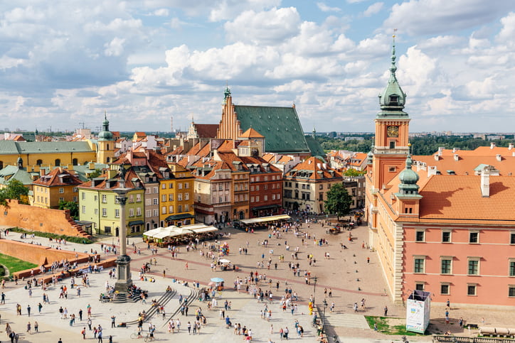 Warsaw old town square with typical Polish buildings terracotta roofs and domed churches